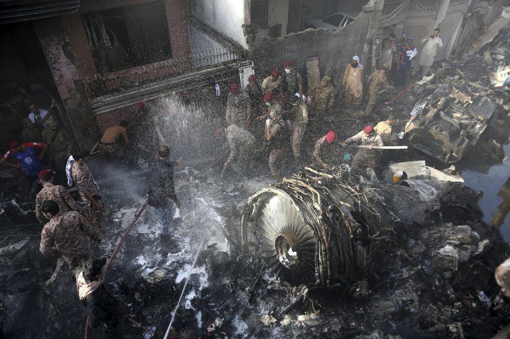 Los rescatistas y los residentes locales buscan sobrevivientes en los restos de un avión que se estrelló con casi 100 personas a bordo en una zona residencial de Karachi en Pakistán 22 de mayo AP Photo Fareed Khan